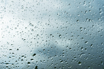 Textured background of window panes with a cloudy background. Natural pattern from a drop of rain on a cloudy background.
