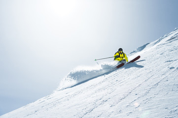 The total length of skiing on fresh snow powder. Professional skier outside the track on a sunny day - obrazy, fototapety, plakaty