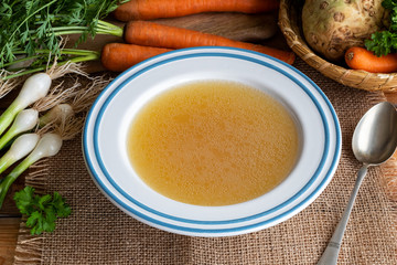 Chicken bone broth and vegetables on a table