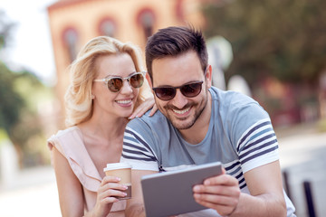 Lovely couple using tablet outdoors