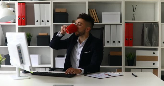 young businessman working on computer and drinking coffee.