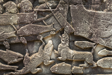 Ancient temple stone carved bas-relief in Angkor Wat. Crocodiles and fishes closeup. Angkor Wat complex Bayon temple