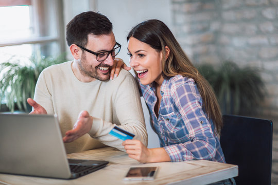 Smiling couple using digital tablet and credit card at home - Powered by Adobe