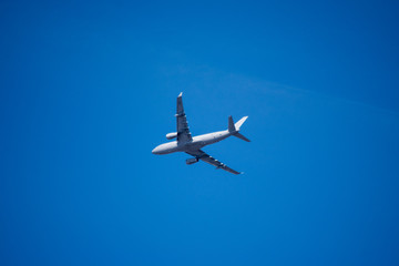 Completely White Airplane against a blue sky.