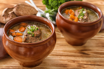 Crock pots with stewed meat on table