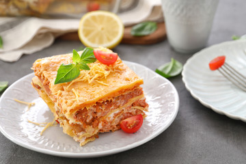 Plate with tasty lasagna on table