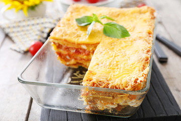 Tasty lasagna in baking dish on table