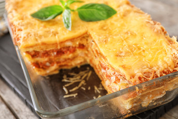 Tasty lasagna in baking dish on table