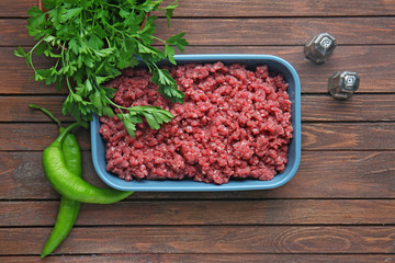 Baking dish with fresh forcemeat on table