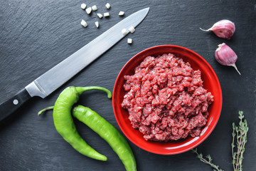 Bowl with fresh forcemeat on black background