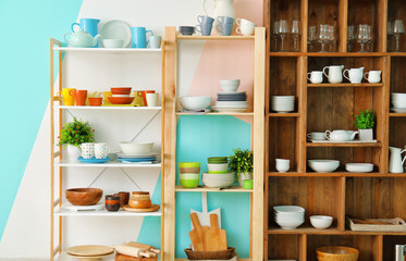 Different clean dishes on wooden shelves