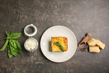 Lasagna with spinach on grey background