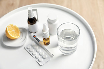 Fototapeta na wymiar Lemon, pills and drugs for cold on table