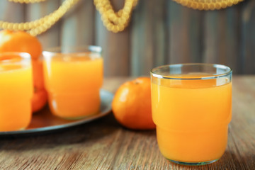 Glass with fresh citrus juice on table