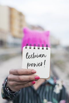woman with a pink hat and the text lesbian power