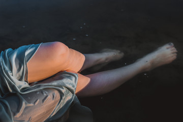 Fototapeta na wymiar Legs of a girl in a river water