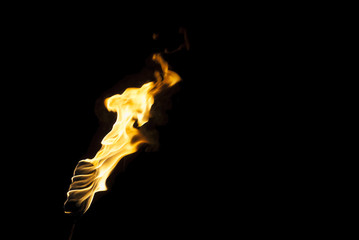 flame of a torch in the dark on a black background, only the fire is visible