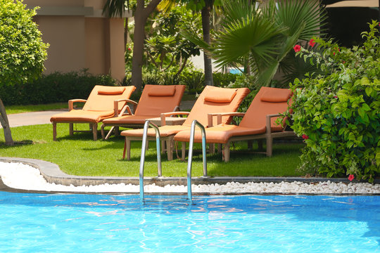 Sunbeds near modern swimming pool at resort