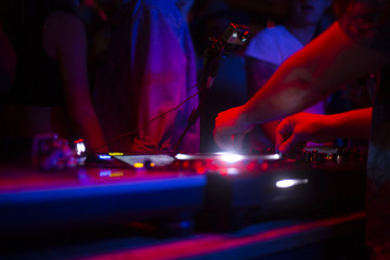 DJ tocando con tornamesas en discoteca