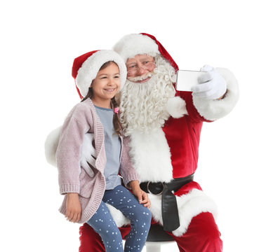 Authentic Santa Claus taking selfie with little girl on white background