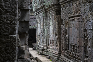 Fototapeta na wymiar Ancient stone ruin in Angkor Wat temple. Carved stone bas-relief gallery. Khmer kingdom heritage ruin in jungle.