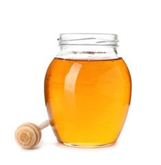 Jar with delicious honey and dipper on white background