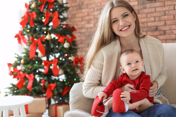 Young woman with baby celebrating Christmas at home