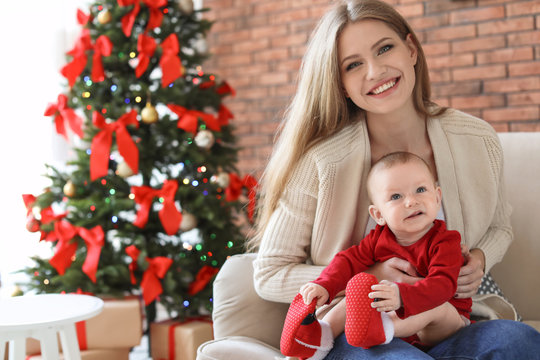 Young woman with baby celebrating Christmas at home