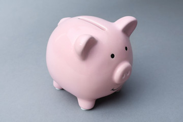 Cute pink piggy bank on gray background