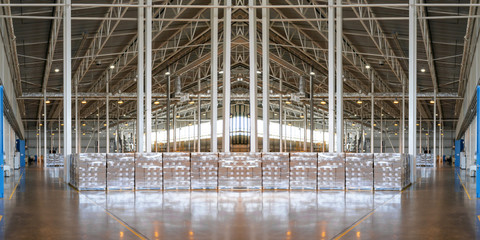 Piece of typical industrial interior. Concept of manufacture, warehouse, storage, factory space. Wide panoramic image.