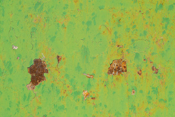 Old green metal door very rusty and cracked by the passage of time. The intense green color of the...