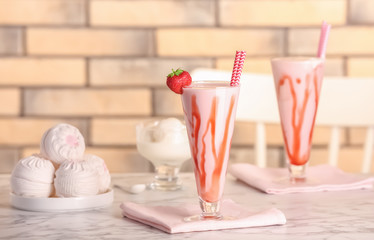 Glasses with delicious milk shakes on table