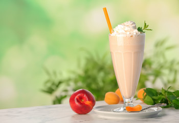 Glass with delicious milk shake on table