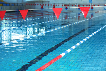 Fototapeta na wymiar Modern swimming pool with blue water, indoors
