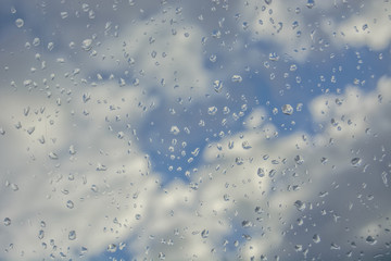 Clouds in the sky through a wet window