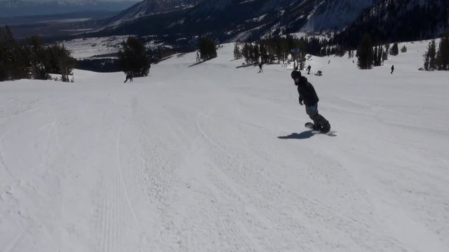 Slow Motion: Snowboarder Gliding Down The Hill