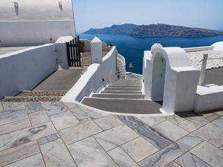 Fototapeta na wymiar Steps and white architecture on Santorini island, Greece. Beautiful summer landscape, sea view.