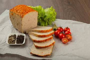 Meat product in the form of bread with spices and on baking paper.