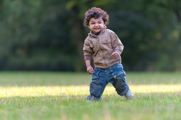 Little boy running cheerful in park garden