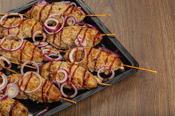 Lulya-kebab. Shish kebab on a stick, minced meat. Traditional Caucasian dish. On a cutting board, with green salad, ketchup, spices