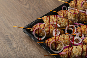 Lulya-kebab. Shish kebab on a stick, minced meat. Traditional Caucasian dish. On a cutting board, with green salad, ketchup, spices