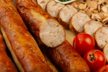 Homemade sausage on a wooden background with seasonings and sauce.
