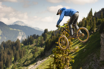 Mountain biker jumps on the background of a beautiful mountain view