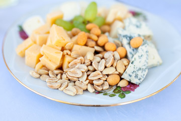 Cheese and nuts plate at the restaurant. Top view.