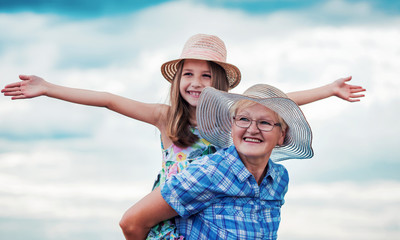 Childhood. Happy little girl and her grandmother enjoys together in a good mood. Family, lifestyle concept