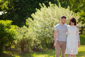 Fototapeta premium Young loving couple at the date, spring at the park, blooming bushes