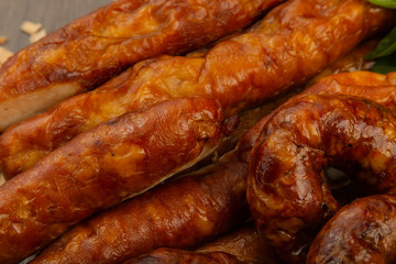 Homemade sausage on a wooden background with seasonings and sauce.