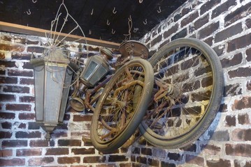 Fototapeta na wymiar Old Bicycle Lamps on Ceiling Hooks on Brick