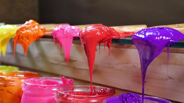 colorful of paint on trowers are dripping to grass barrel. store of ink or paint for print on tee shirt in tee shirt factory