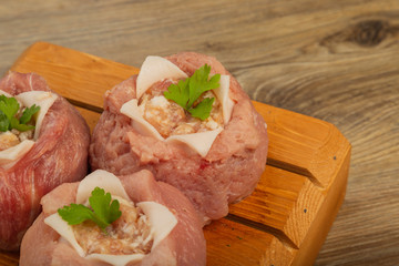 Semi-finished meat, seasoned on a wooden background.